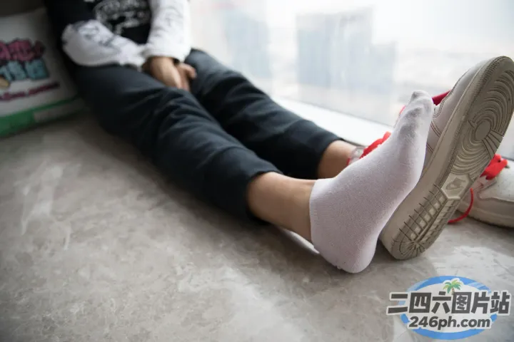 有人坐在地板上，双脚抬起，双脚着地