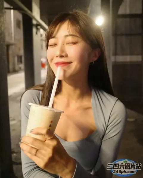 一个女人拿着饮料，用吸管喝饮料