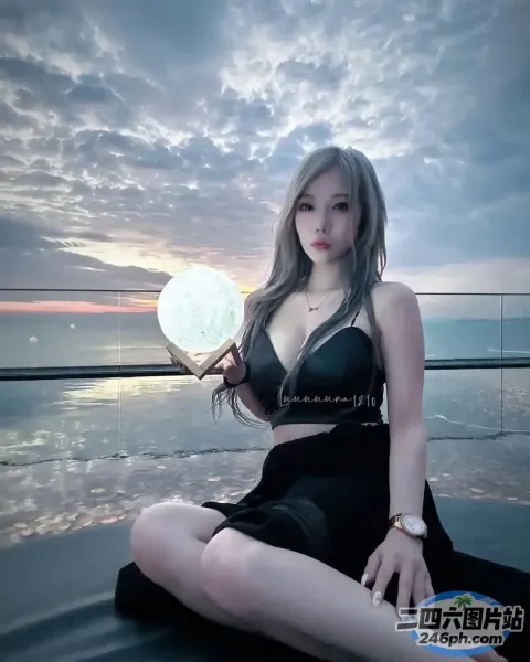 一个穿着黑色连衣裙的女人坐在海滩上的特写