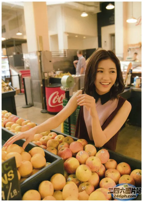 杂货店里的阿拉夫德女人，手里拿着苹果和橙子