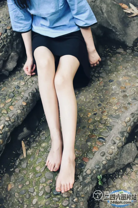 有一个女人坐在岩石上，双叉