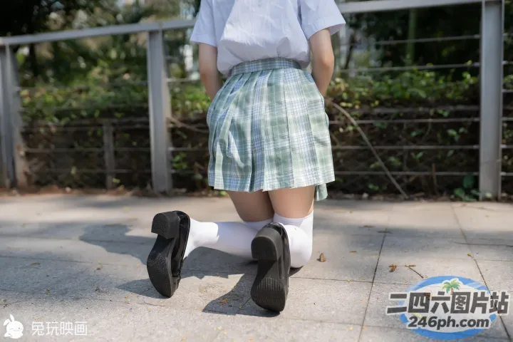 人行道上走着一个穿着裙子和袜子的女孩