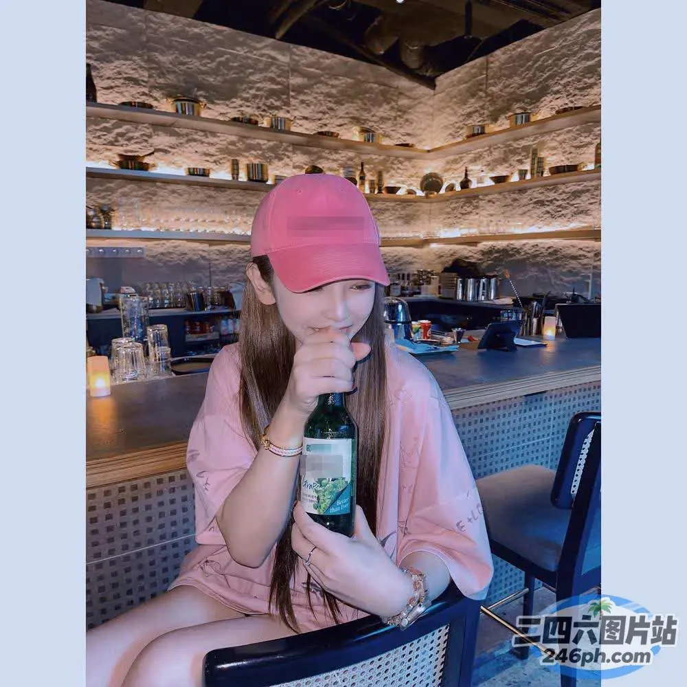 坐在椅子上喝着一瓶葡萄酒的女人