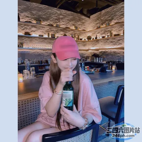 坐在椅子上喝着一瓶葡萄酒的女人