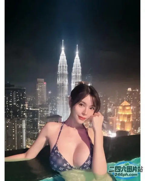 一位穿着比基尼上衣的女人坐在泳池中，可以欣赏到城市的美景