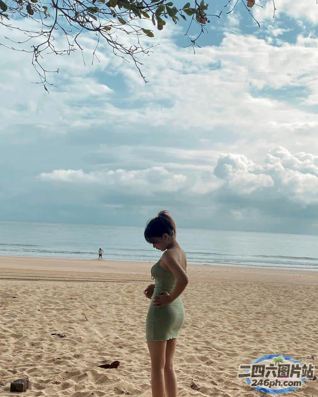 孕妇站在海滩上，背景是风筝