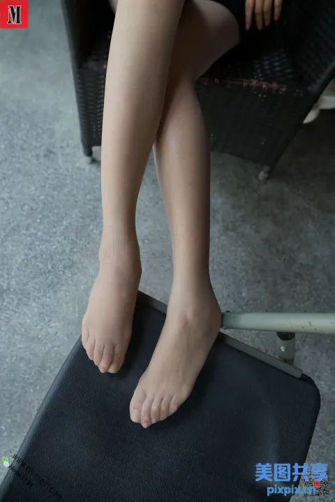 有一位女士坐在椅子上，双脚放在笔记本电脑上