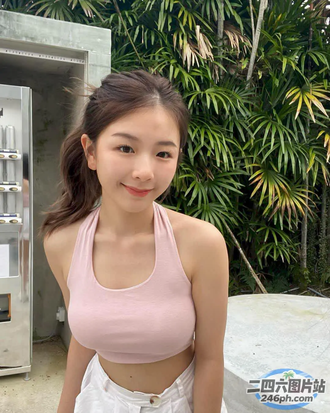 有个女人站在冰箱前，手里拿着饮料