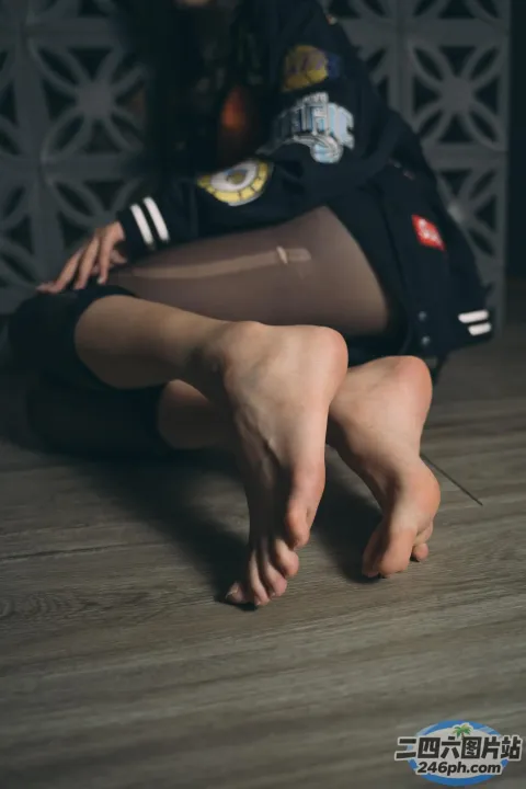 有一个女人坐在地板上，双叉