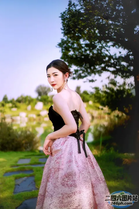 站在公园里的穿着粉红色连衣裙的 Arafed 女人