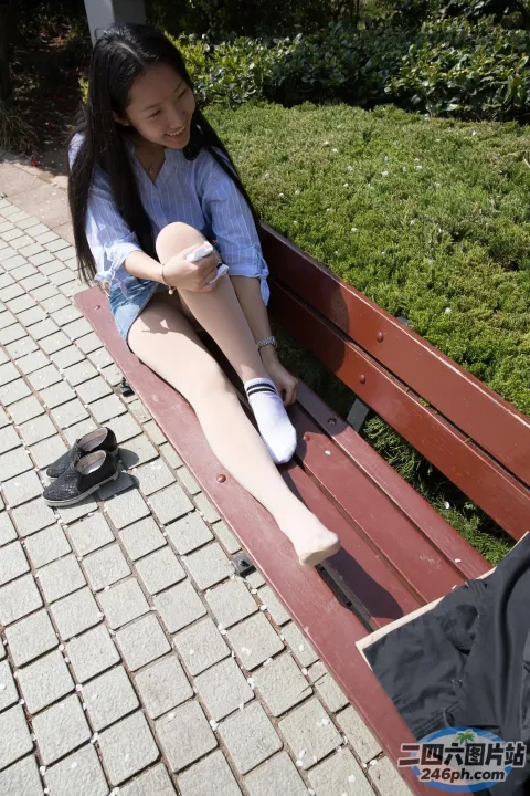 有个女人坐在长凳上，双腿交叉