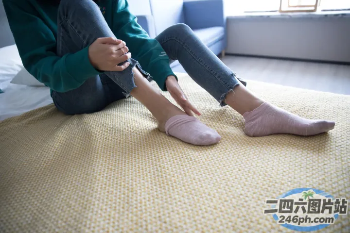 有人坐在床上，脚放在床上