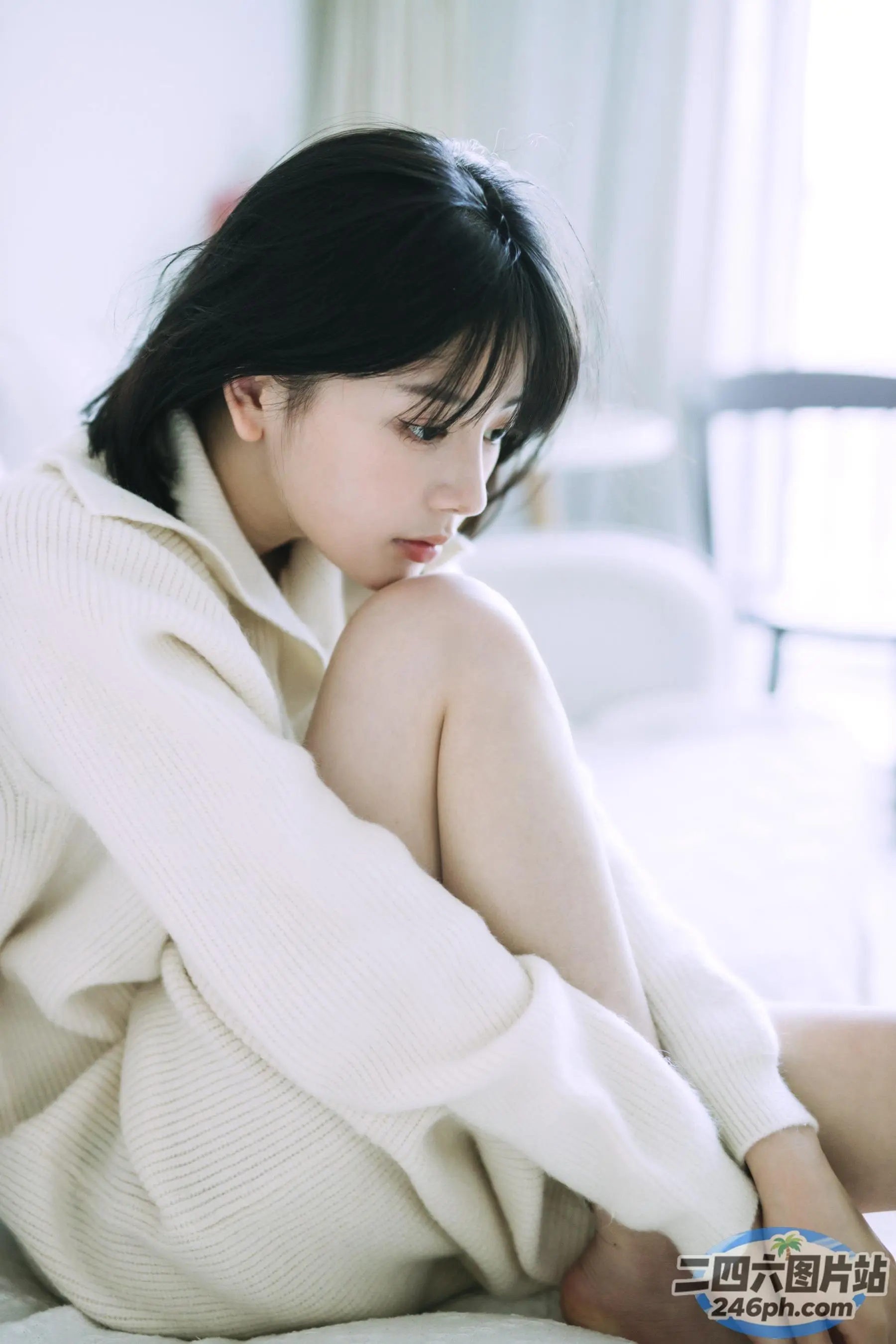 一个女人坐在床上，双腿交叉的特写