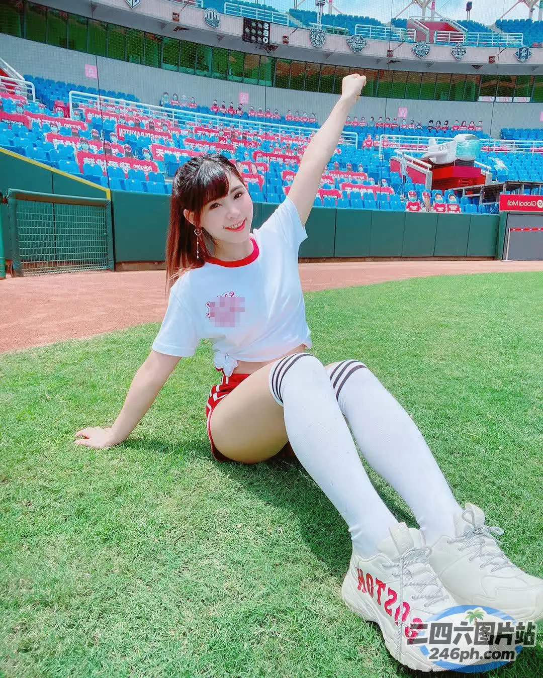 一名女子坐在棒球场的草地上