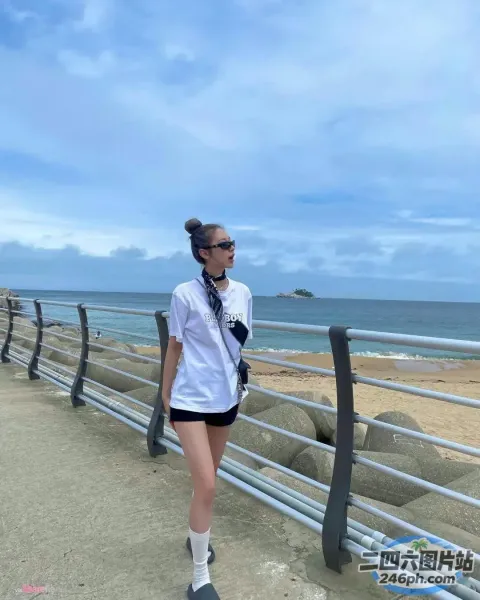 海边的木板路上走着一个女人