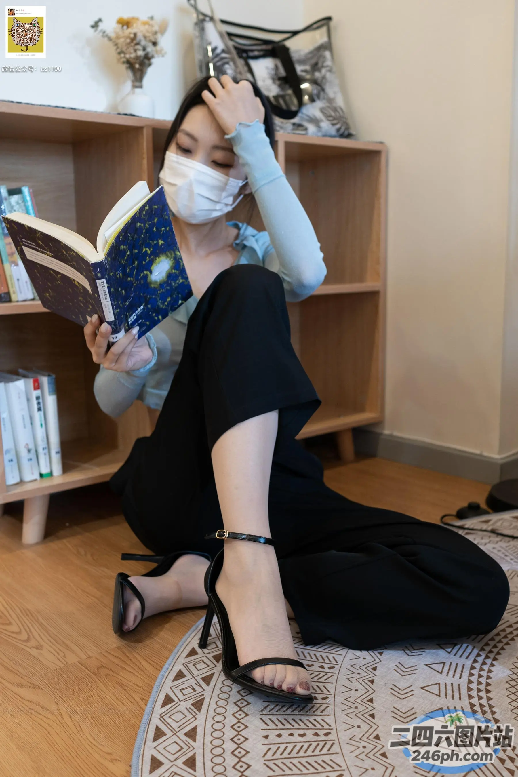 戴着口罩坐在地板上看书的女人