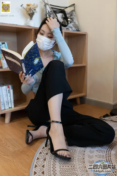 戴着口罩坐在地板上看书的女人