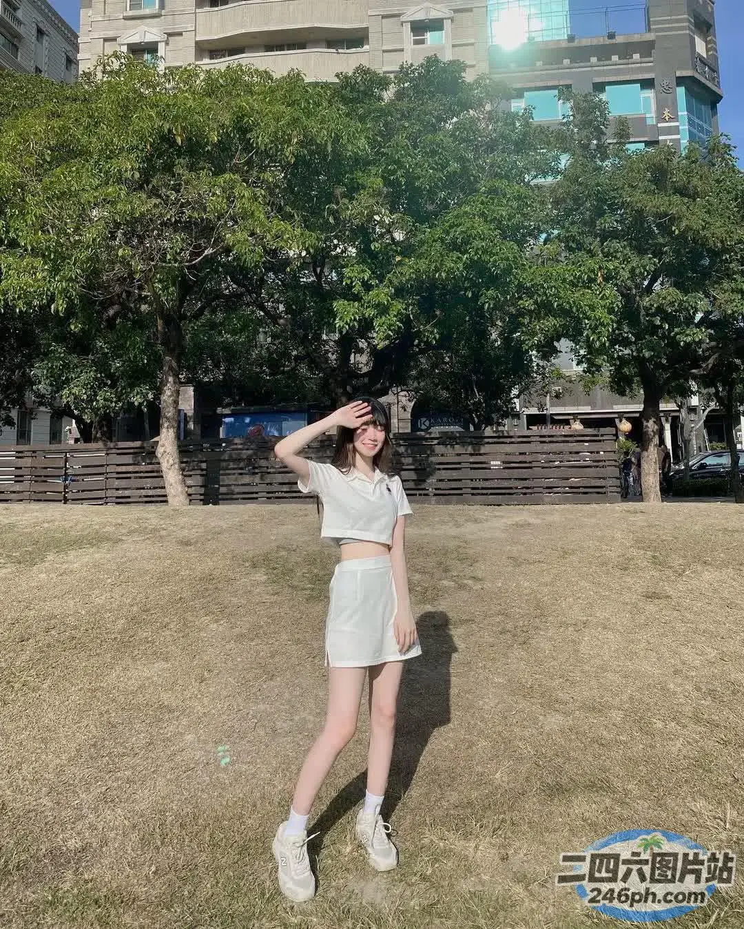 一个穿着白衬衫和白裙子站在田野里的女人