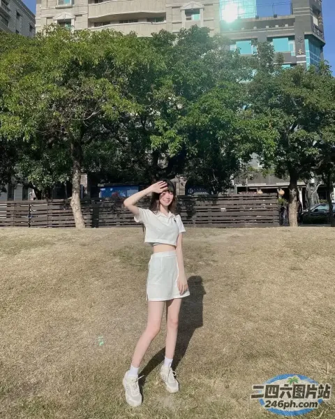 一个穿着白衬衫和白裙子站在田野里的女人