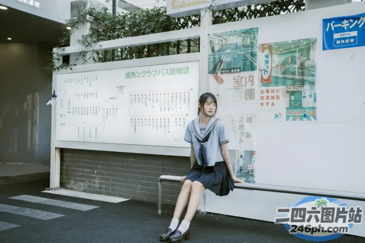 有个女人坐在墙前的长凳上