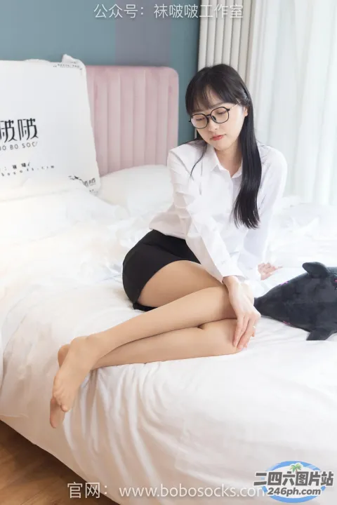 阿拉夫德女人坐在床上，腿上放着一只猫