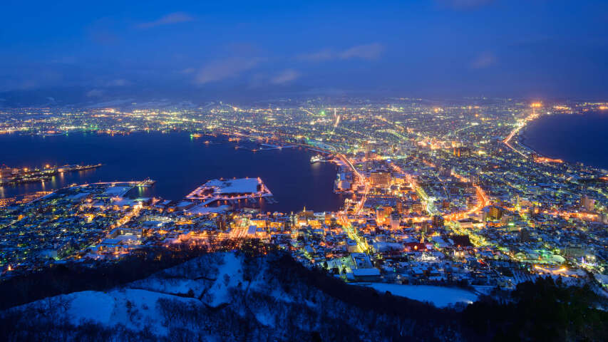 以湖光和山脉为背景的城市夜晚的 arafed 景观