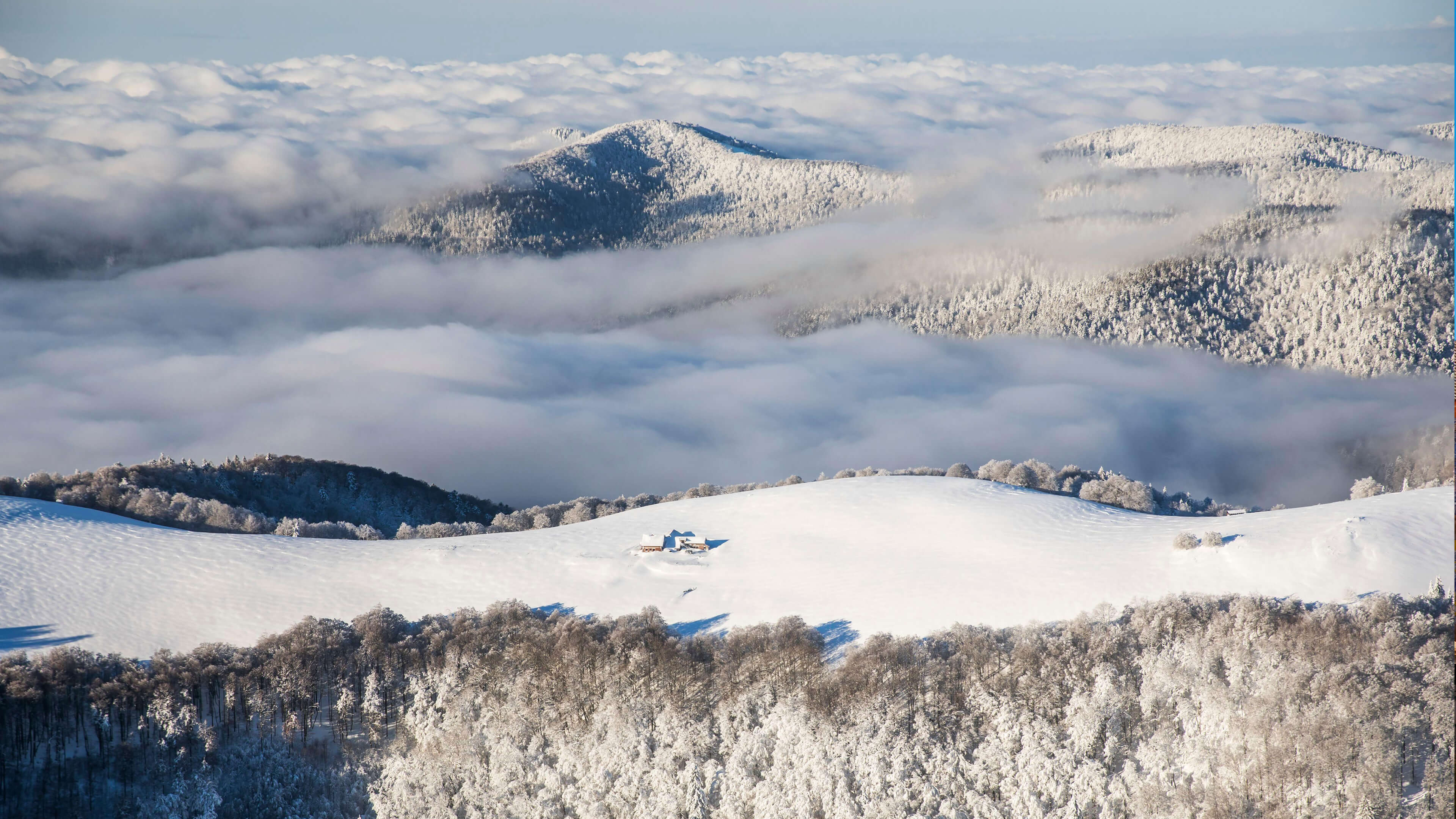 白雪皑皑的群山和云层，孤独的单板滑雪者