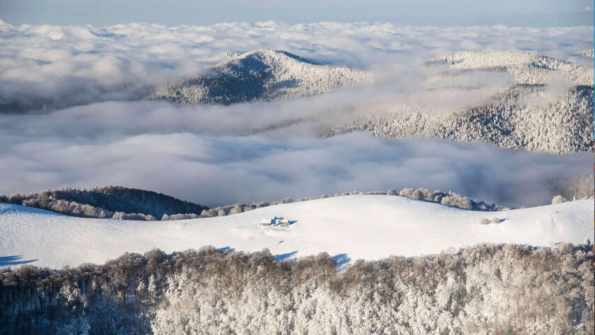 白雪皑皑的群山和云层，孤独的单板滑雪者