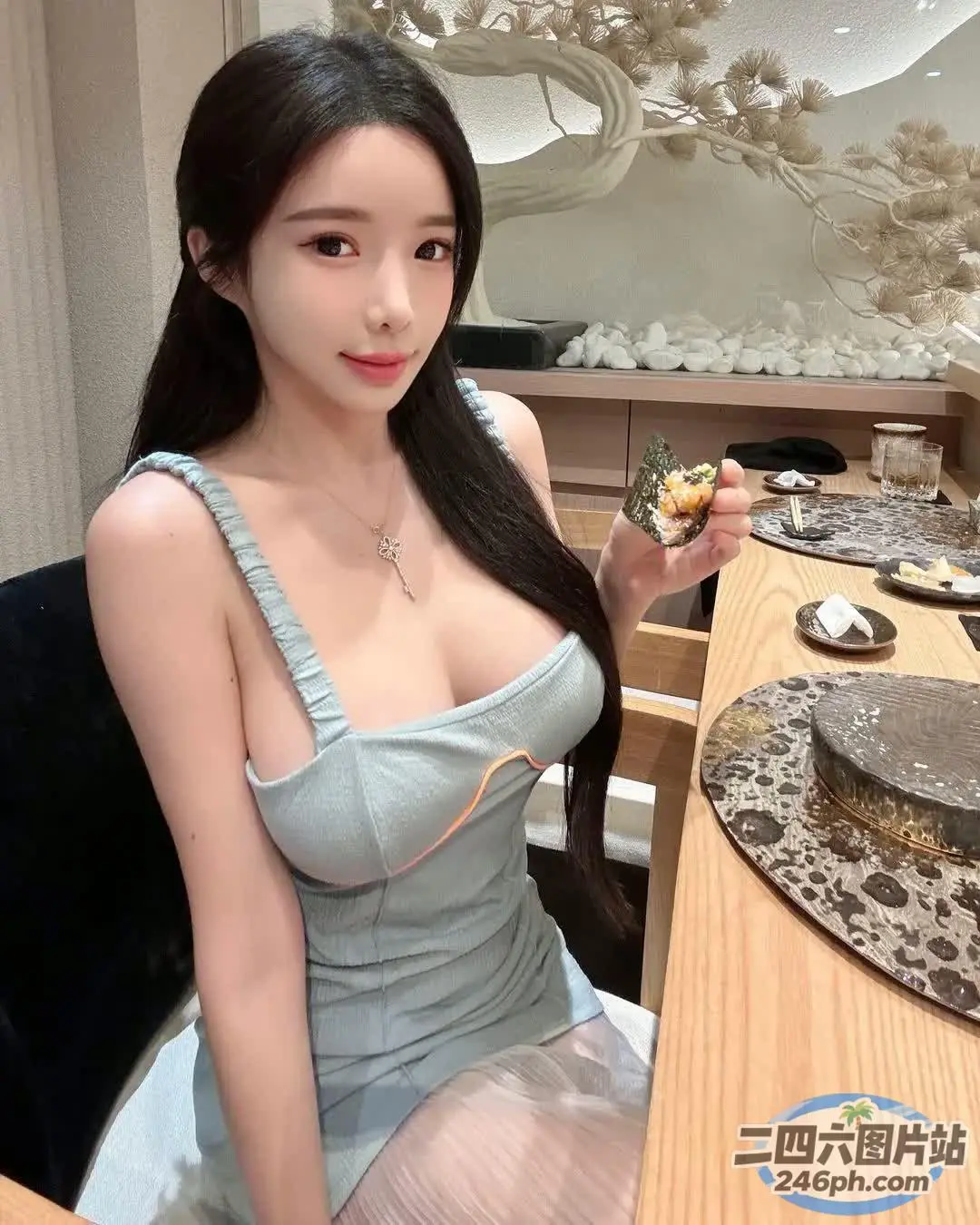 坐在桌子旁的蓝色连衣裙的 araffe 亚洲女性
