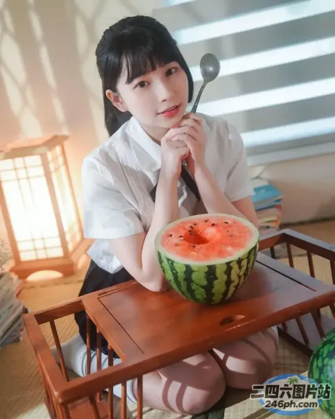 有个女人坐在桌子旁，桌上放着一个西瓜