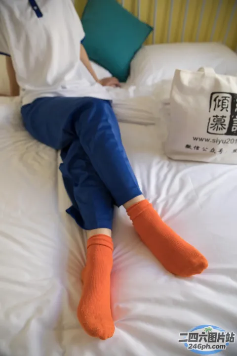 有一个人躺在床上，穿着橙色的袜子