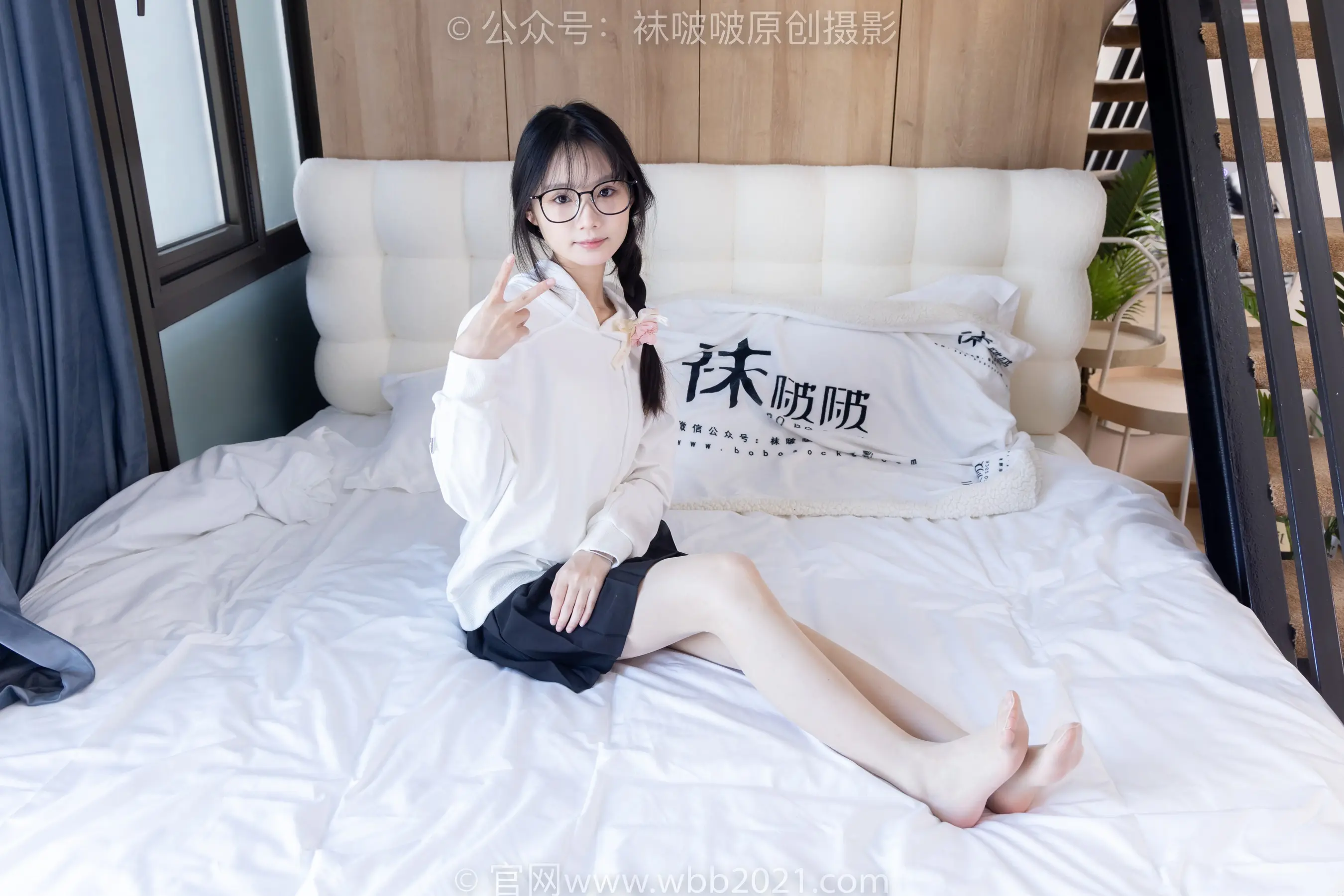 床上坐着一个女人，手里拿着遥控器