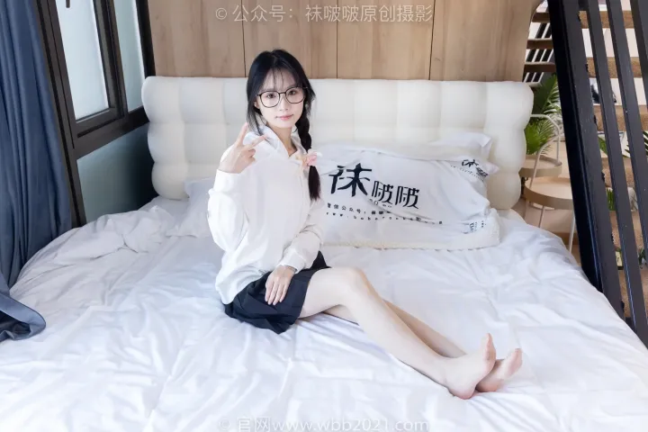 床上坐着一个女人，手里拿着遥控器