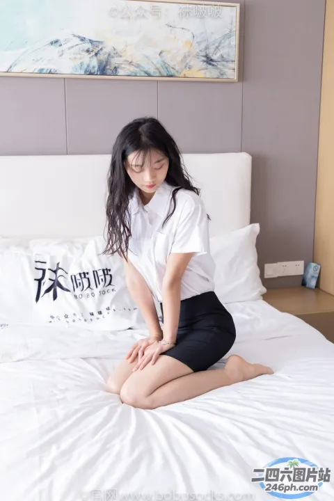 穿着白衬衫坐在床上的阿拉夫德亚洲妇女