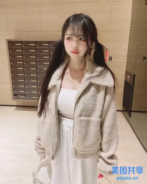 一个穿着白色连衣裙和夹克的女人站在房间里