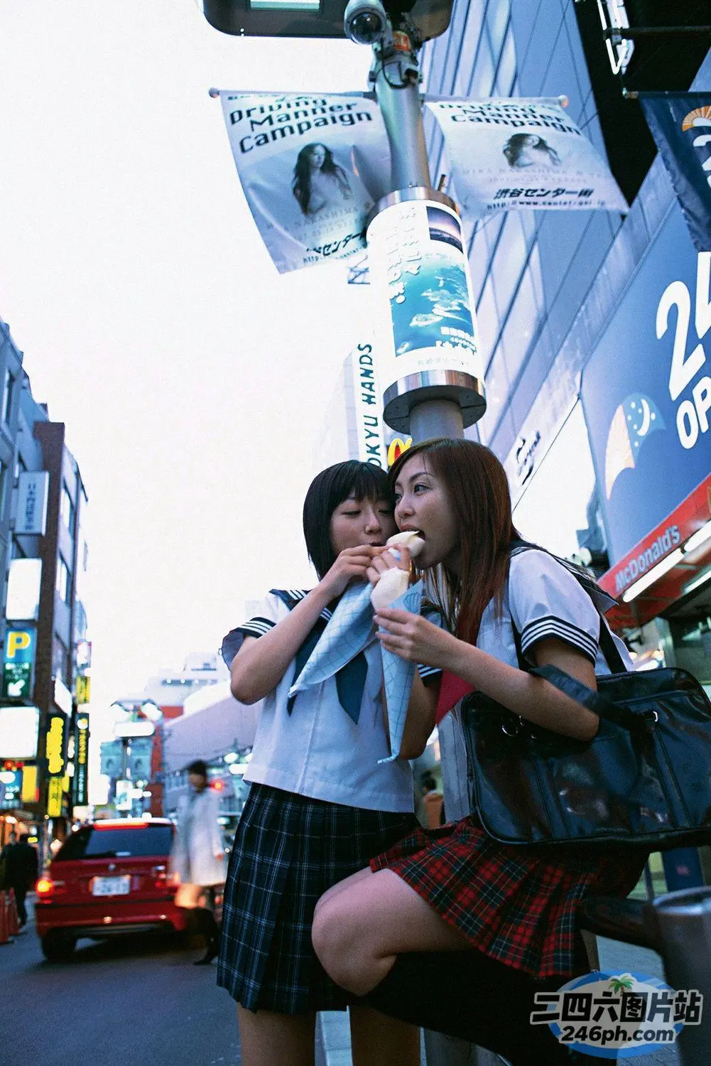 两个亚裔女孩站在城市街角吃冰淇淋
