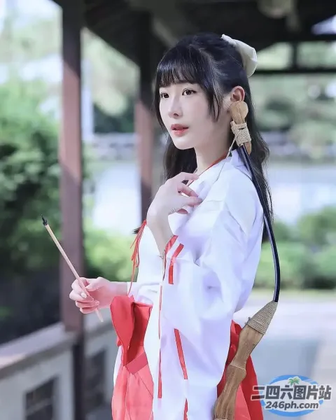 有一个穿着红白相间的连衣裙的女人，手里拿着一根棍子