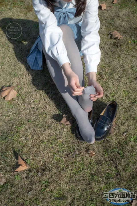 身穿白衬衫和灰色紧身衣的 Araffe 女子系鞋带
