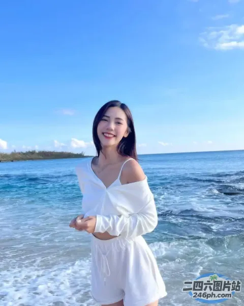 一个女人站在蓝天碧水的海滩上