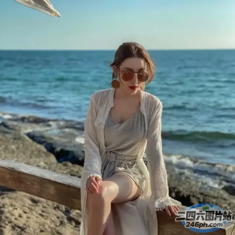 女人坐在海边的木凳上，一只鸟在头顶飞过