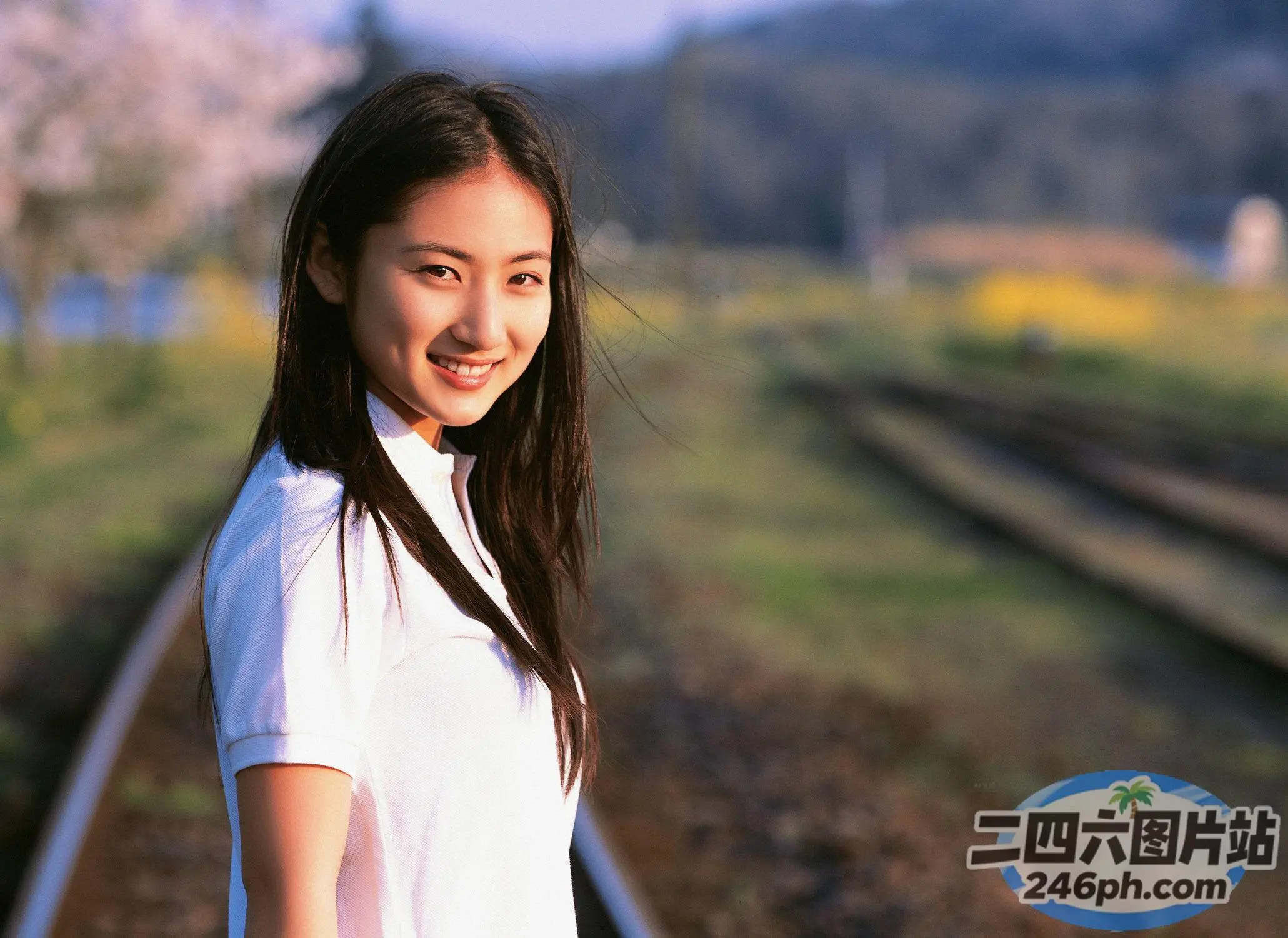 有个女人站在火车轨道上面带微笑