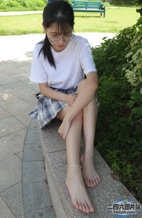 有一个年轻的女孩坐在石凳上，双腿交叉