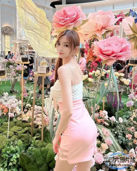 有一位女士手持花伞站在花园里