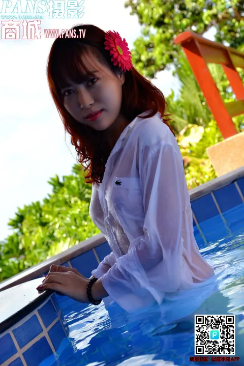 一个穿着白衬衫的女人坐在游泳池里的特写