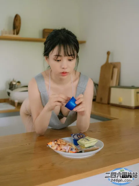 有个女人坐在一张桌子旁，桌上放着一盘食物