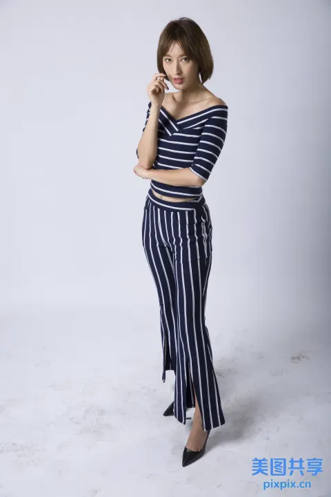 穿着条纹上衣和裤子的 arafed 女人在手机上说话