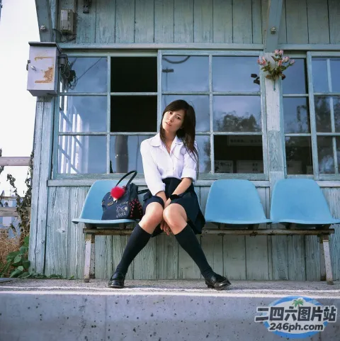 坐在建筑物前长凳上的 arafed 亚洲妇女