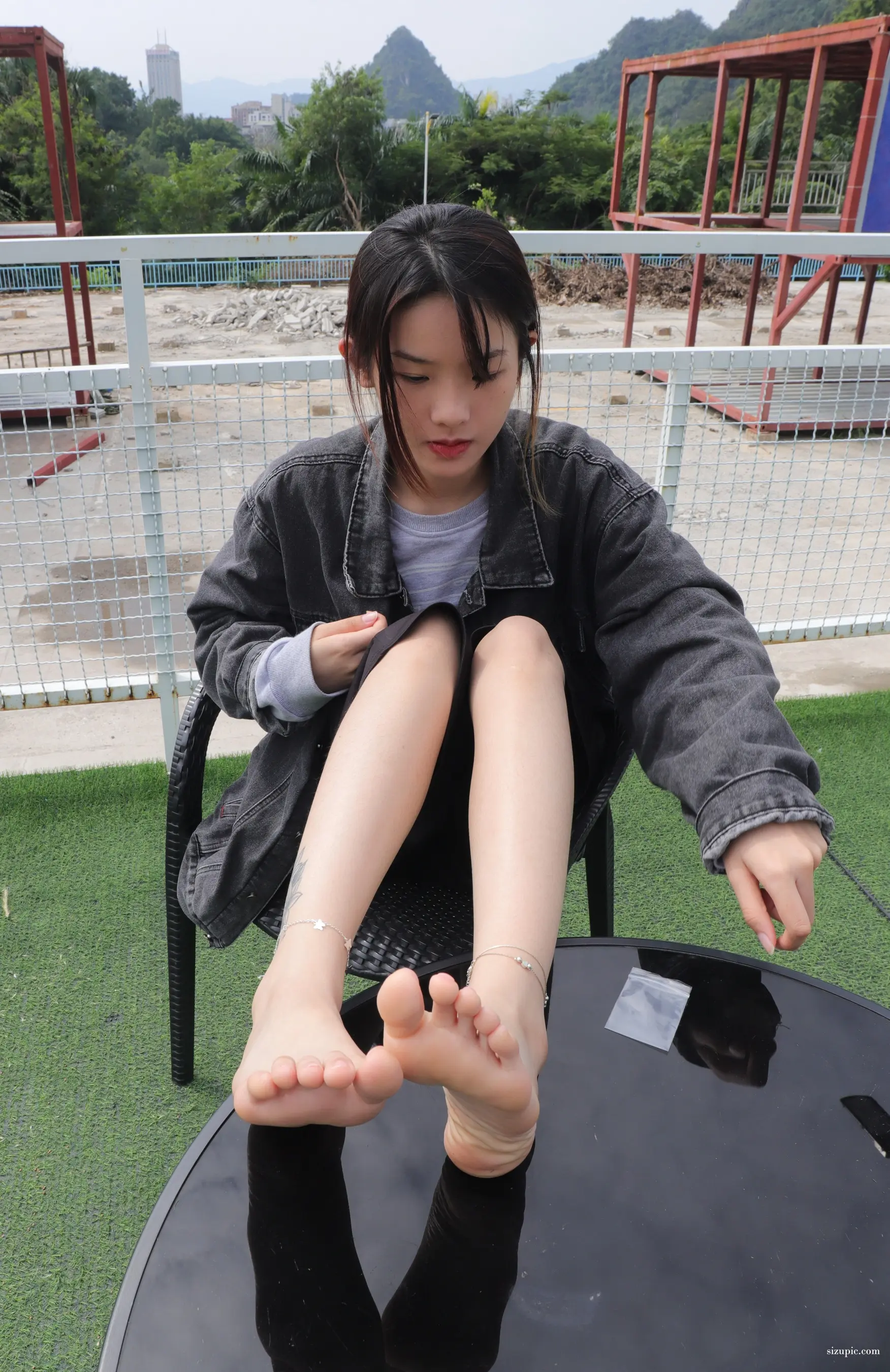 阿拉菲坐在椅子上，双脚放在桌子上