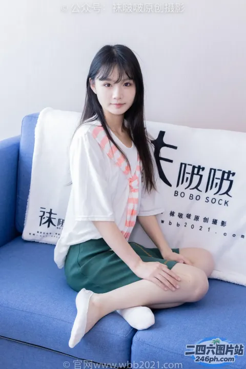 一个女人坐在蓝色的沙发上，手里拿着一个枕头和一个枕头