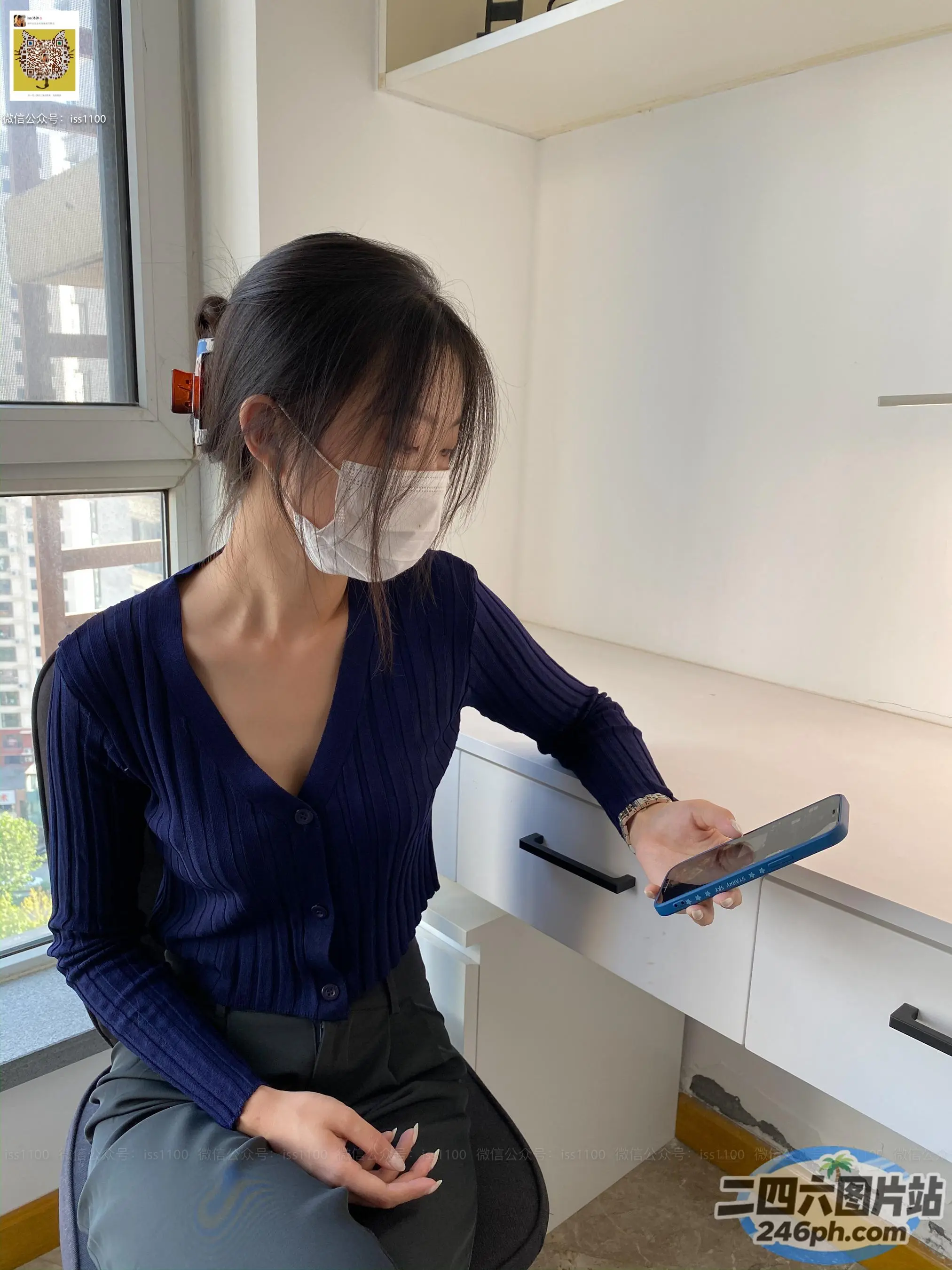 戴着口罩和手机坐在桌子上的女人